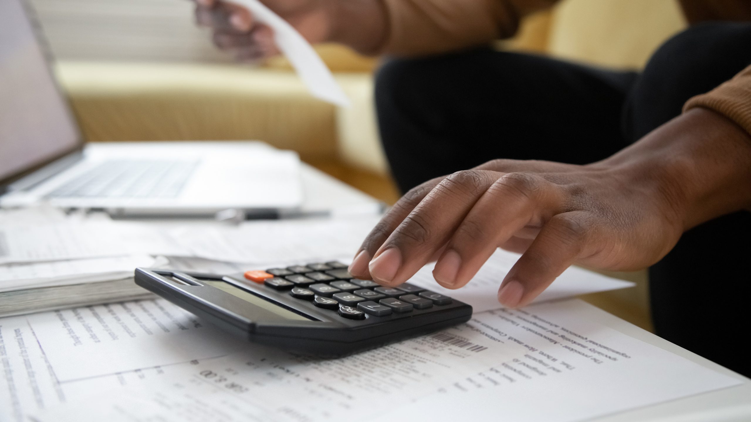 Close up of a hand using a calculator and working out a budget